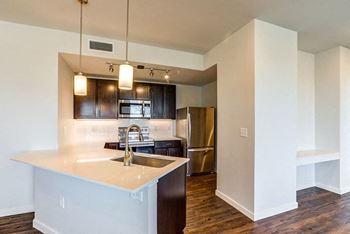 kitchen with a large island and a stainless steel refrigerator at Connect at First Creek,  Denver, CO